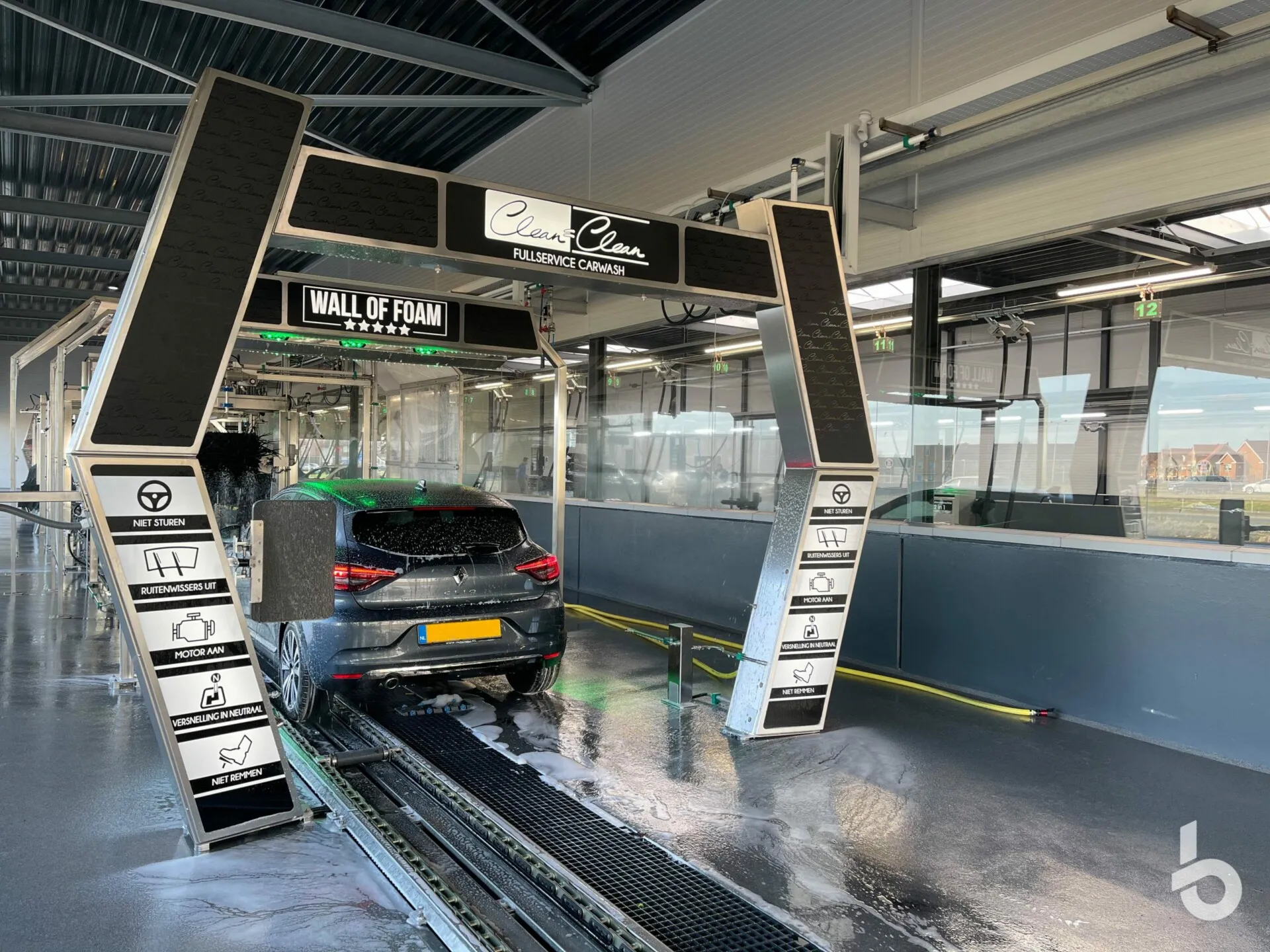 Auto rijdt door de Wall of Foam in de wasstraat van Clean = Clean